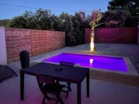 a patio with a table and a purple pool at La Paillote Exotique Spa in Beaucaire