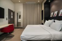 a bedroom with a bed and a desk and a red chair at Maison Nô - Hôtel et Rooftop in Lyon