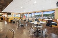 a restaurant with tables and chairs and windows at Alhonna Resort in Lake Ozark