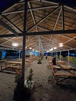 Eine Gruppe von Holztischen in einem Gebäude mit Lichtern in der Unterkunft Samba Bluewater Resort in Olongapo