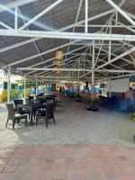 eine Terrasse mit Tischen und Stühlen unter dem Dach in der Unterkunft Samba Bluewater Resort in Olongapo