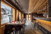um restaurante com mesas, cadeiras e um bar em SWISSPEAK Resorts Zinal em Zinal