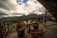 a table and chairs on a balcony with mountains at Chalet Papa Basili in Gudauri