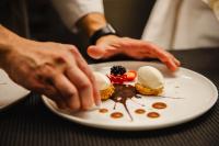 a person is reaching for a plate of desserts at Le Castel Cabourg hôtel & SPA- Restaurant La Calypso in Cabourg