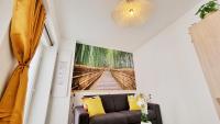 a living room with a couch and a painting on the wall at Le Ptit Paradis - Calme - Wifi - Cour privée - Relax BNB in Mulhouse