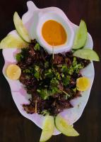 a plate of food with a bowl of sauce and apples at The Lumbini Hotel & Restaurant in Lumbini