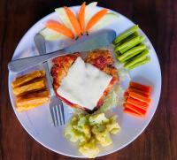 a plate of food with vegetables and a knife and fork at The Lumbini Hotel & Restaurant in Lumbini