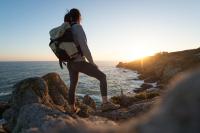 a woman walking on the rocks near the ocean at Naéco Erdeven in Erdeven