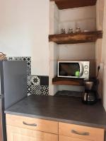 a kitchen with a refrigerator and a microwave at Gîte les Pieds dans l&#39;eau bord de Sèvre, 10 min du Puy du Fo in Treize-Vents