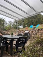 a patio with a table and chairs under a white canopy at Gîte les Pieds dans l&#39;eau bord de Sèvre, 10 min du Puy du Fo in Treize-Vents