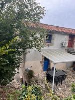 a patio with a table and a solar roof at Gîte les Pieds dans l&#39;eau bord de Sèvre, 10 min du Puy du Fo in Treize-Vents
