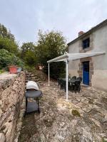 a patio with a table and a grill in front of a house at Gîte les Pieds dans l&#39;eau bord de Sèvre, 10 min du Puy du Fo in Treize-Vents