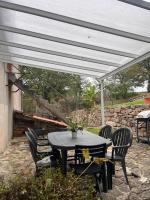 a patio with a table and chairs under a white canopy at Gîte les Pieds dans l&#39;eau bord de Sèvre, 10 min du Puy du Fo in Treize-Vents