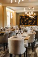 a dining room with tables and chairs with wine glasses at Le Castel Cabourg hôtel & SPA- Restaurant La Calypso in Cabourg