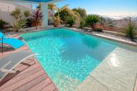 a swimming pool with a deck and a house at Prestigious villa with panoramic sea view in Bandol
