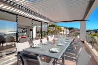 a dining table and chairs on the patio of a house at Prestigious villa with panoramic sea view in Bandol