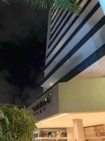 een gebouw met een hoog gebouw op de achtergrond bij Mais espaço com estilo e vista para o mar in João Pessoa