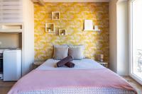 - une chambre avec un grand lit et un mur jaune dans l&#39;établissement AU PIED Du Grand Bassin, à Castelnaudary