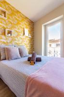 - une chambre avec un grand lit et un mur jaune dans l&#39;établissement AU PIED Du Grand Bassin, à Castelnaudary