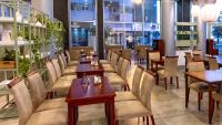 a restaurant with wooden tables and chairs and windows at Hotel Riviera in Mar del Plata