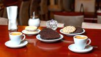 a table with plates of cakes and cups of coffee at Hotel Riviera in Mar del Plata