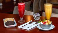 a table with two drinks and a bowl of fruit at Hotel Riviera in Mar del Plata