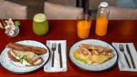 a table with two plates of food and two glasses of orange juice at Hotel Riviera in Mar del Plata