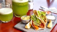 a wooden table with two tacos and two drinks at Hotel Riviera in Mar del Plata