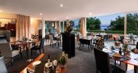 a restaurant with tables and chairs and a large window at Romantik Hotel Residenz am See in Meersburg