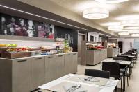 un ristorante con tavoli e sedie e un buffet di Amedia Hotel Milan, Trademark Collection by Wyndham a Milano