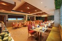 a restaurant with tables and chairs in a room at PARK RESIDENCY ARCADIA in Alwaye