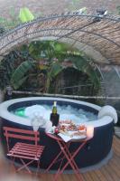 einen Whirlpool mit einem Tisch und einer Flasche Wein in der Unterkunft Maisonnette rurale de charme in Plessis-Saint-Benoist