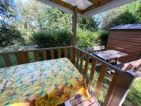 a deck with a table with a colorful tablecloth on it at Mobilehome climatisé avec TV pour 4 à 6 personnes in Boofzheim