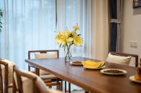 Una mesa de comedor con flores amarillas en un jarrón. en Hangzhou Ziwei Boutique Homestay, en Hangzhou