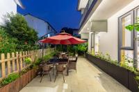 Un patio con una mesa y sillas y una sombrilla. en Hangzhou Ziwei Boutique Homestay, en Hangzhou