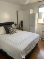 a bedroom with a large white bed with a window at Penthouse avec jacuzzi in Asnières-sur-Seine