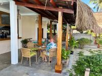 San IsidroYapak Beach Villas的坐在庭院桌子上的男人