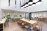 a dining room with tables and chairs and windows at Blu Monkey Hub and Hotel Krabi Town in Krabi town