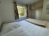 a white bed in a room with a window at Mobilehome climatisé avec TV pour 4 à 6 personnes in Boofzheim