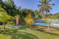 einen Pool in einem Garten mit Palmen in der Unterkunft Villa Fleur de Lune in Saint-Paul