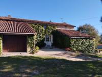 a house with a garage and ivy at Maison au calme avec vue étang in Clessé