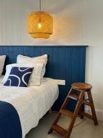 a bedroom with a blue wall and a bed with a stool at LE CLOS DE FLO 17 in Saint-Rogatien
