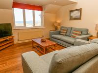 a living room with two couches and a tv at The Beach House in Newquay