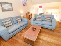 a living room with two blue couches and a coffee table at The Beach House in Newquay