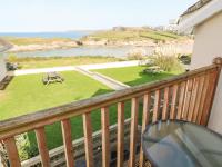 a balcony with a table and a view of a park at The Beach House in Newquay