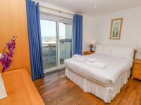 a bedroom with a bed and a large window at The Beach House in Newquay