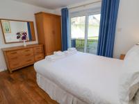 a bedroom with a large white bed and a window at The Beach House in Newquay