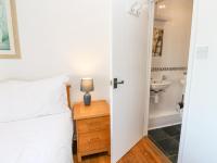 a bedroom with a bed and a bathroom with a sink at The Beach House in Newquay