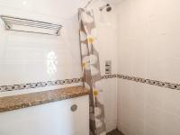 a bathroom with a shower with white tiles at The Beach House in Newquay