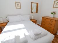 a bedroom with a white bed with two towels on it at The Beach House in Newquay